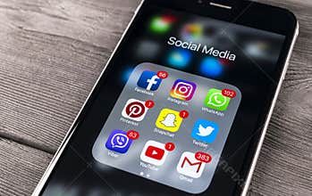 Apple iPhone 7 on wooden table with icons of social media facebook, instagram, twitter, snapchat application on screen. Smartphone