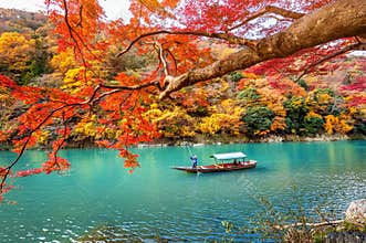 Boatman punting the boat at river. Arashiyama in autumn season along the river in Kyoto, Japan