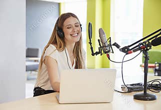 Happy young woman broadcasting in a studio, close up