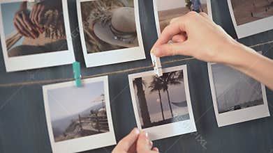 Woman hanging photo of her travel on the wall, vacation photos