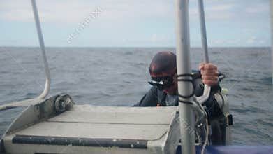 Diver boarding a boat from the sea