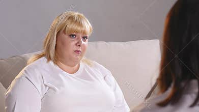 A fat woman complains to a dietician about her figure. Fat woman crying