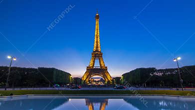 Eiffel Tower day to night timelapse and people sitting on the grass in the evening in Paris, France