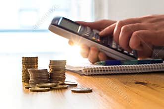Man using calculator to count money savings and living costs.