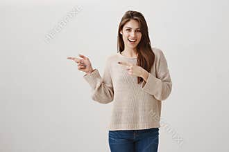 Girl is ready to except every proposal for drink. Portrait of charming caucasian brunette with excited smile pointing