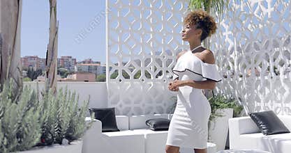 Confident woman in dress posing on balcony