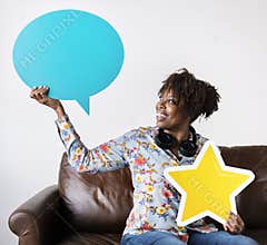 Happy African American holding copy space speech bubble and a star sign