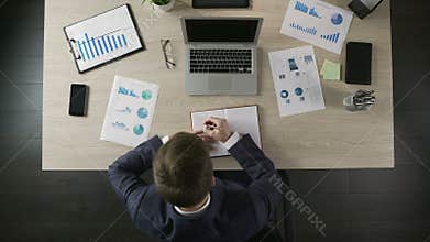 Responsible businessman writing in notebook, making to-do list, time management
