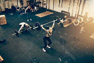 Fit people working out with weights together in a gym