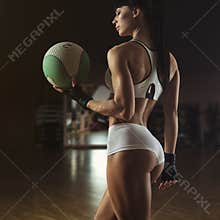 Beautiful pilates instructor holding a fitness ball