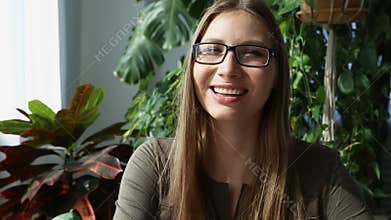 Work at home. young beautiful woman is working at the table by the window in the house - closeup. modern ecological