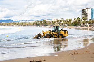 Tractor clean beach on coastline Costa Dorada, Salou, Spain.