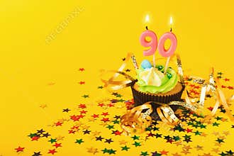 90th birthday cupcake with candle and sprinkles