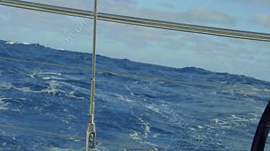 Slow motion view of Atlantic with long waves in sunny afternoon from stern of yacht