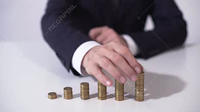 Banker putting coin on pile, deposit interest growing, successful investment