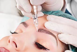 Beautician Performing Eyebrow Tattoo on Woman\'s Face: Permanent Brow Makeup in Beauty Salon