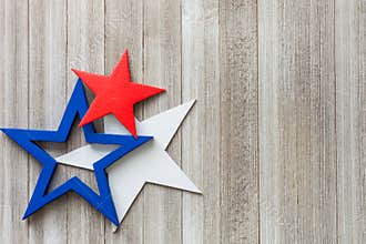 Wooden red, white and blue stars on a rustic background with copy space/4th of July background concept