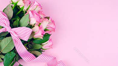 Mother`s Day background of pink roses with copy space on pink wood table.