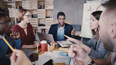 Multiethnic colleagues talking at office meeting. Happy young business people developing partnership agreement 4K.