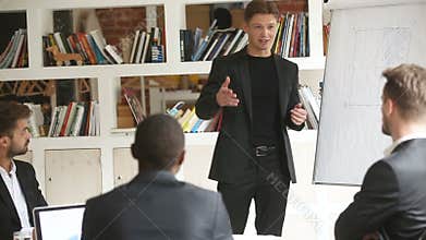 Confident businessman giving presentation in meeting room with flip chart