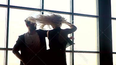Hot dance two professional dancers. A pair of dancers beautifully dance against the background of a large window closee