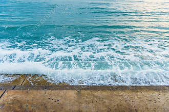 Sea water wave splashing on embankment, forming a spray.Exotic w