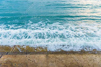 Sea water wave splashing on embankment, forming a spray.Exotic w
