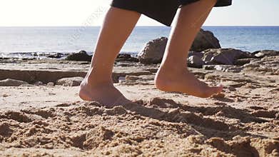 Barefoot feets of boy running at the beach