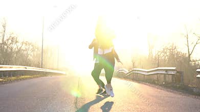 A pair of dancers perform a synchronized ballet jump at dawn, leaks. Slow motion
