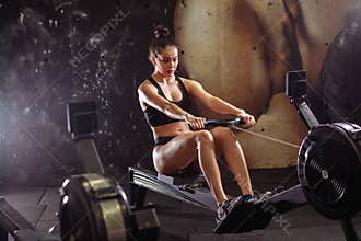 Female using rowing machine in gym. woman doing cardio workout in fitness club.