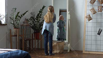 Carefree little girl making funny faces in mirror