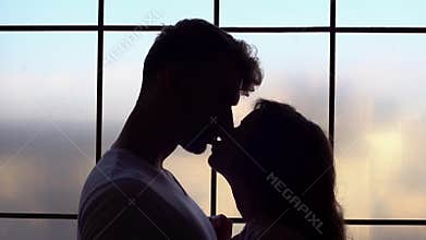 Young couple at home together saint valentine`s day concept dusk kissing in the dark close-up