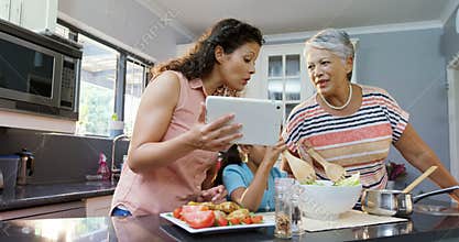 Mother and granny helping the girl to mix the salad 4K 4k