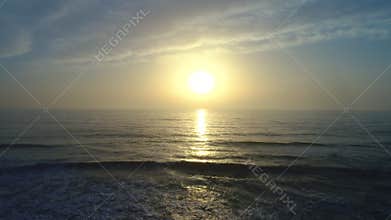 Aerial drone view of beautiful sunrise over the sea water and beach
