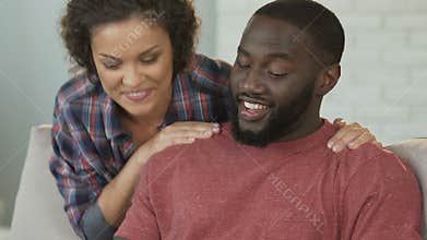 Happy couple ordering furniture online on tablet by application, playing games