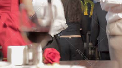 Glass of red wine standing on restaurant table, people dancing to music at party