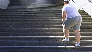 Obese man climbing stairs, overweight causes pain in joints, varicose veins