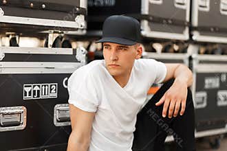 Stylish model man in a black cap and white T-shirt
