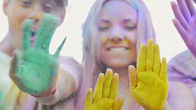 Happy friends waving hands painted in colorful powder, gesturing hello, party