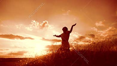 Girl folded her hands in prayer silhouette lifestyle at sunset. woman praying on her knees. slow motion video. Girl