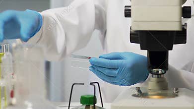 Lab assistant smears blood sample, HIV testing, cancer research, viral epidemic