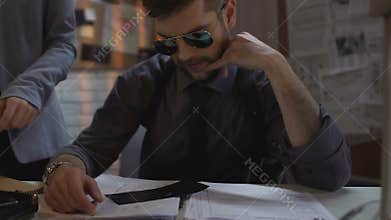 Private detectives examining case materials for crime solution, cooperation