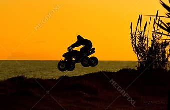 Silouette of quad bike jumping