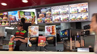 Pan shot of people ordering food and worker changing price tag