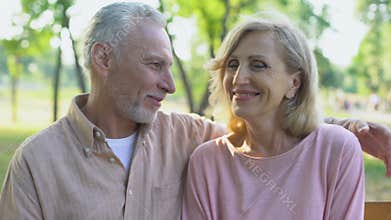 Happy old couple looking in camera, embracing, smiling satisfied with life