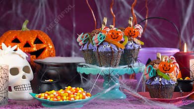 Halloween candyland drip cake style cupcakes in party table setting.