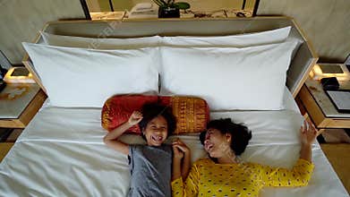 Little girl and mother lying down on bed
