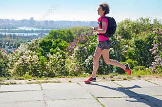 Woman runner run commutes to work with backpack, city morning run commuting and fitness concept