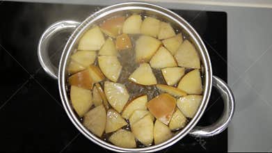 Apple compote is cooked in a saucepan