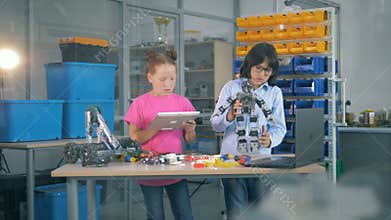 Young kids working together in a laboratory room. School children use laboratory equipment to construct a toy robot.